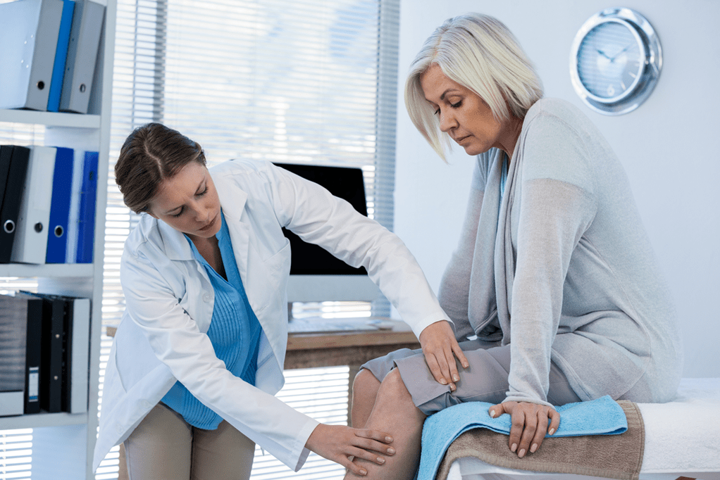 Un médico examina a un paciente que sufre de artrosis y necesita terapia.